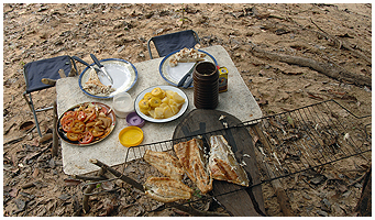 Grilled fish, bananas, tomato and onion salad and tapioca for lunch - deliciously prepared over a small fire on the river bank